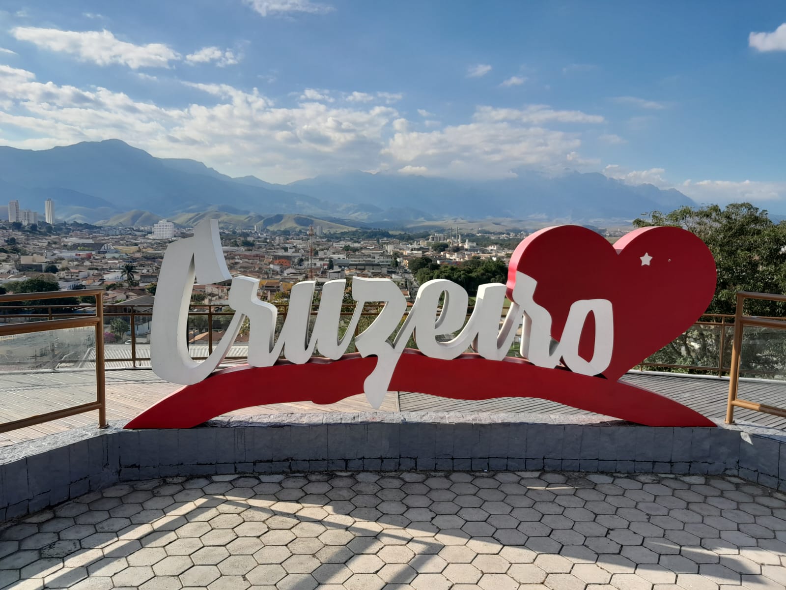 Letreiro Cruzeiro com o coração e a cidade ao fundo